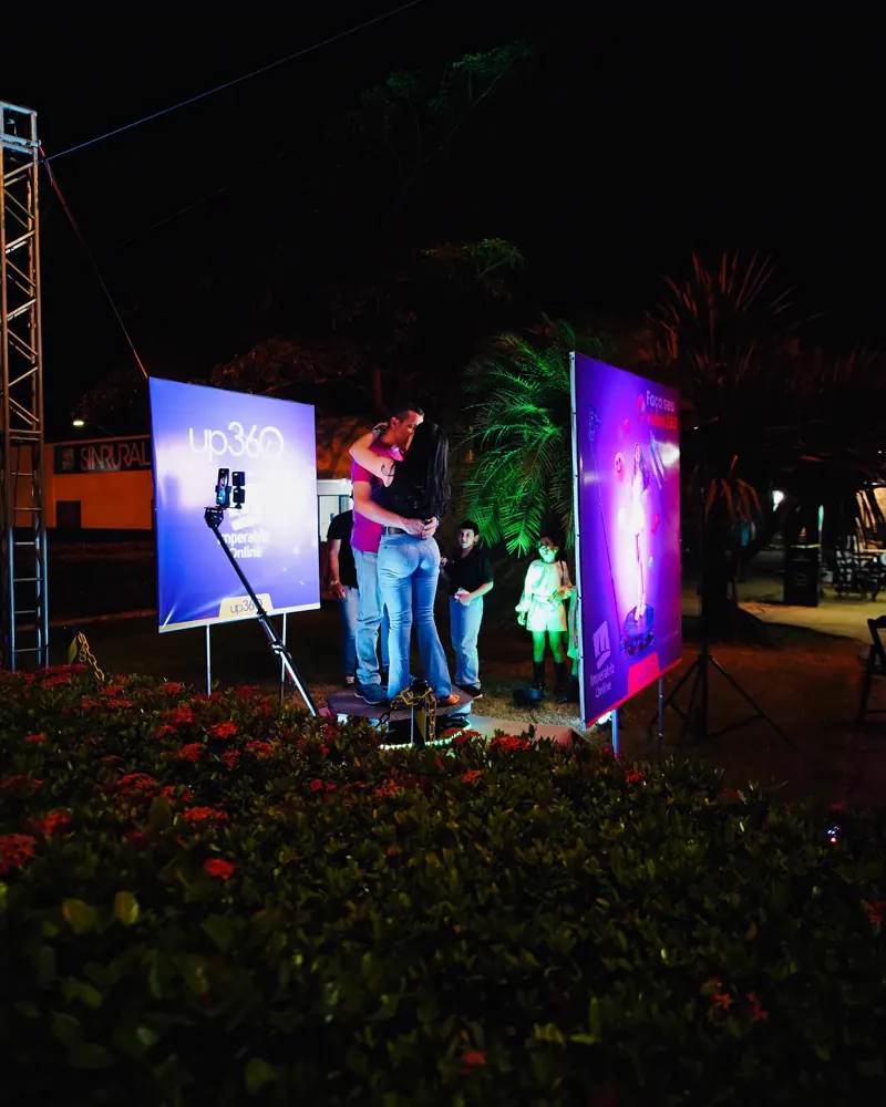 Casal se beijando na Plataforma 360 iluminada em evento ao ar livre